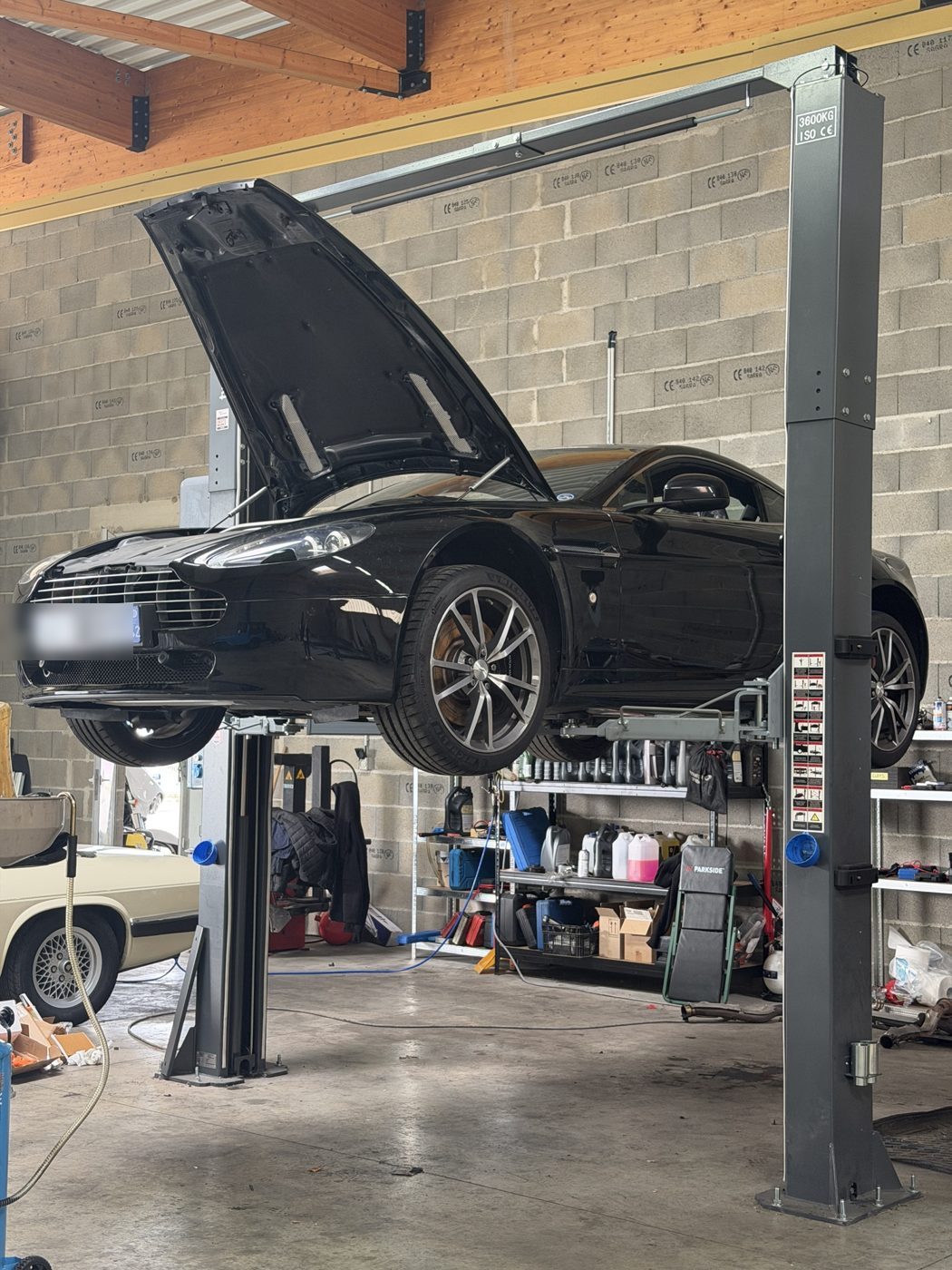 Aston Martin V8 Vantage sur pont élévateur — 99 L'Atelier